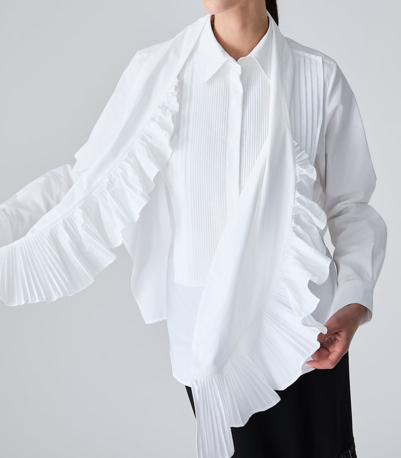white long-sleeve blouse with pleated details, paired with a white scarf that has dramatic ruffle and pleated details, worn by a model against a light gray studio background.